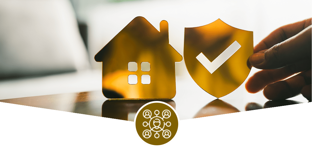 Hand holding shield next to house model