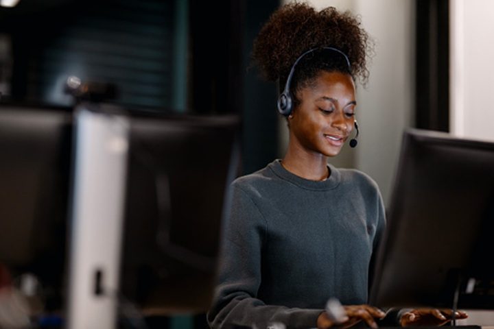Smiling woman using desktop in office